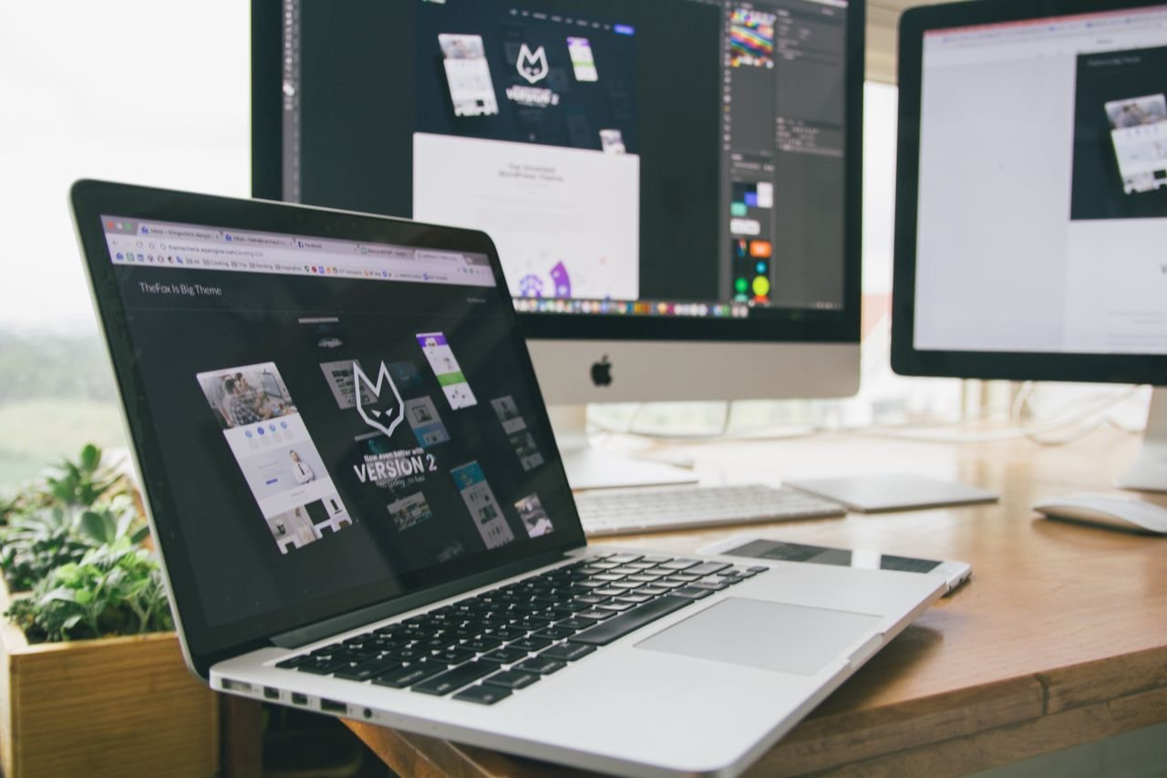 The Art of Drawing Readers In: Your attractive post title goes here A stylish workspace featuring a laptop and monitors displaying design software.